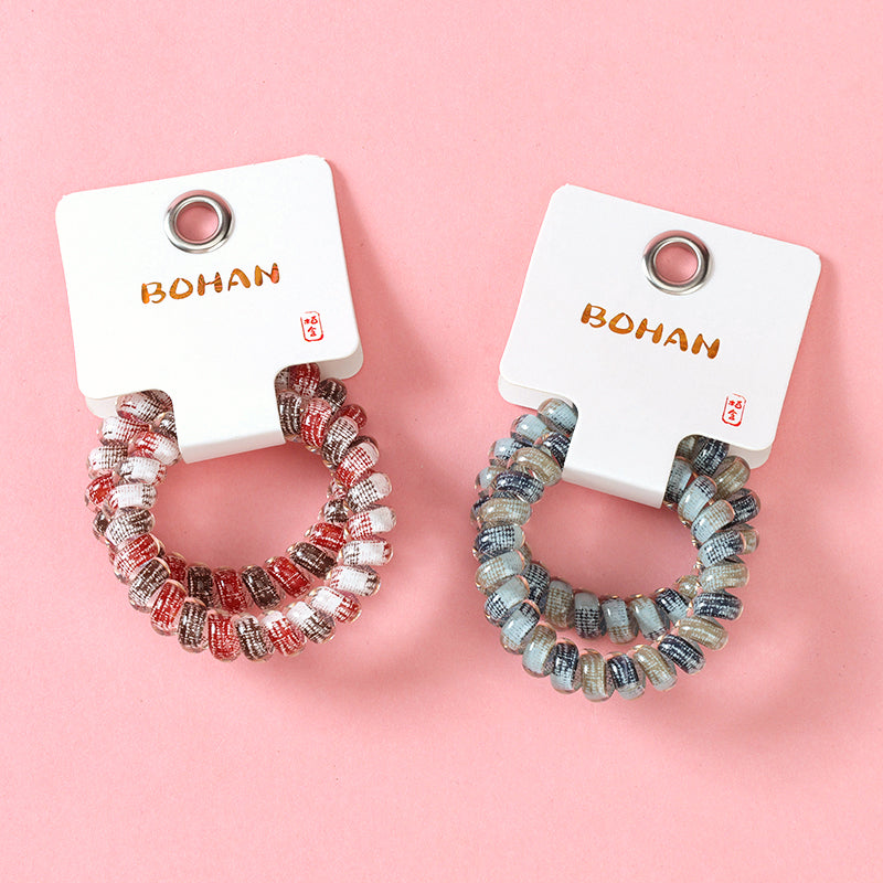 M42 two gray-series telephone cord hair ties in a box