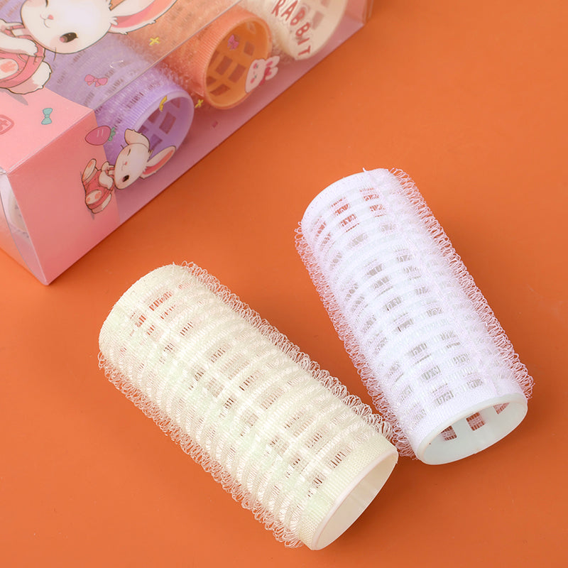 086 box containing four sticky hair curlers M.50