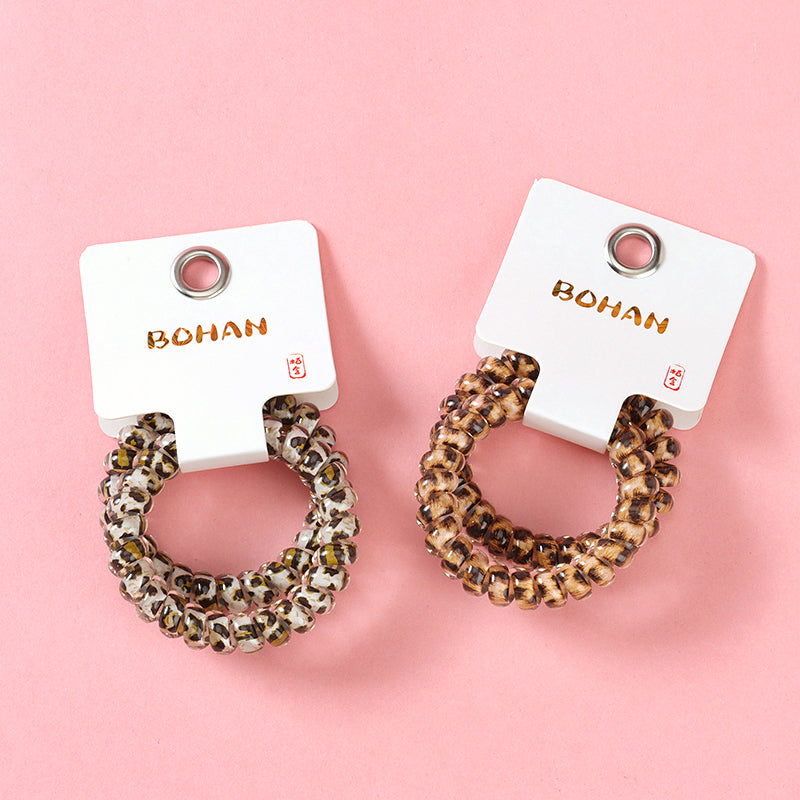M42 two leopard-print telephone cord hair ties in a box