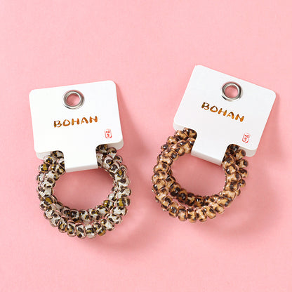 M42 two leopard-print telephone cord hair ties in a box