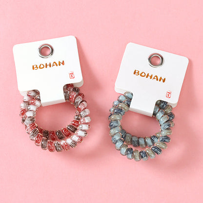 M42 two gray-series telephone cord hair ties in a box