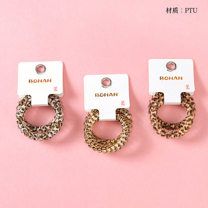 M42 two leopard-print telephone cord hair ties in a box