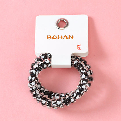 M42 two milk-pattern polka dot telephone cord hair ties in a box